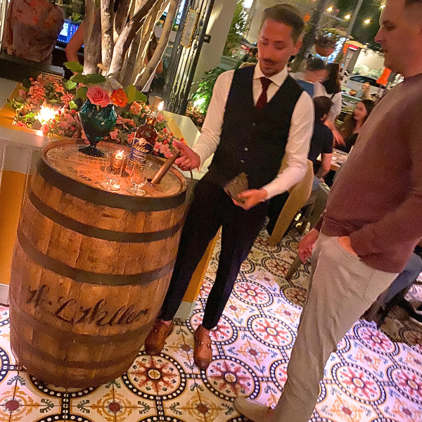 Beau du Bois helps a customer thief whiskey from his Weller Full Proof barrel.