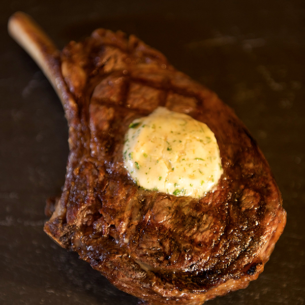 Whiskey compound butter atop a seared cowboy steak 
