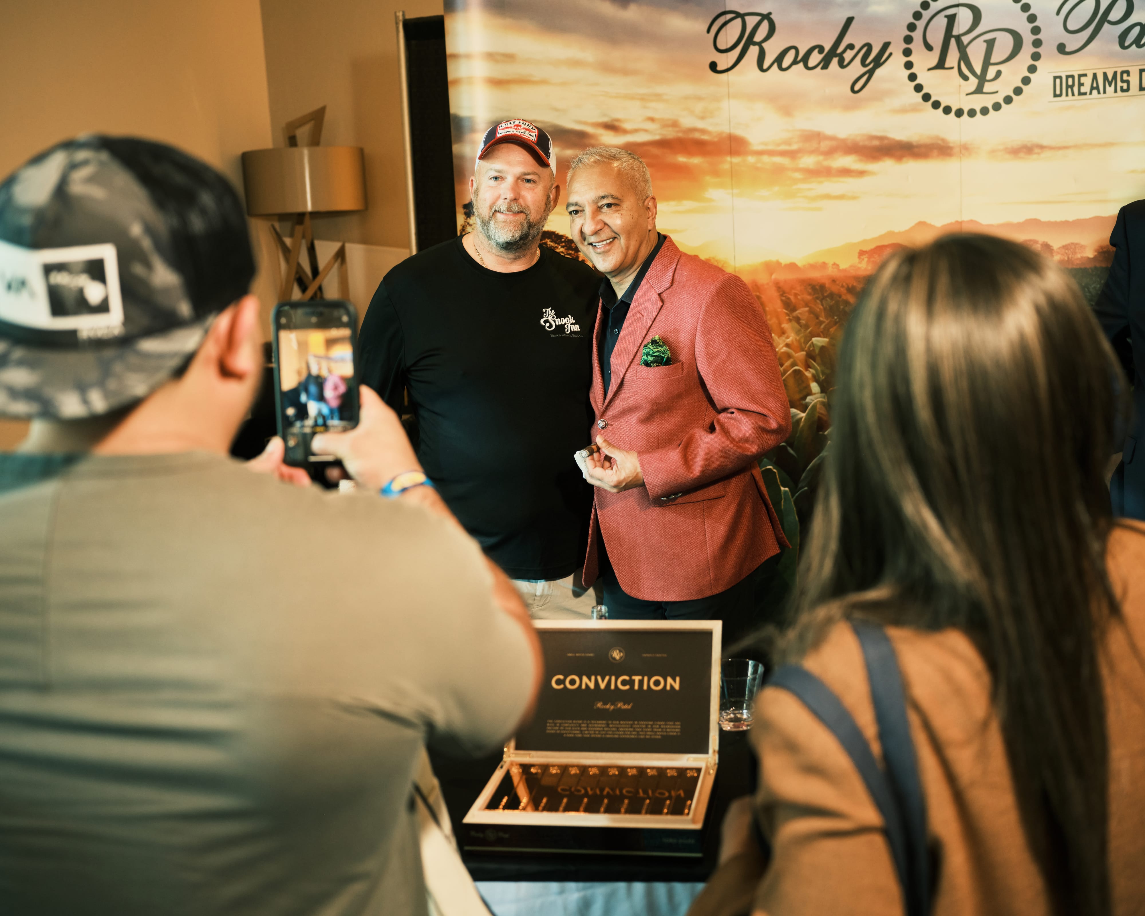 Cigar maker Rocky Patel takes a photo with an attendee.